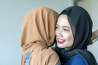 Müslüman kız tesettürlü gülümsüyor ve eğleniyor.