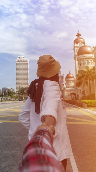 Muszlim turista pár Kuala Lumpurban kövessen kézhúzás közben. — Stock Fotó