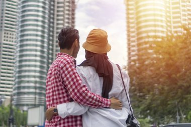 Kuala Lumpur 'daki turist çift modern binaya bakıp gülümsüyor.