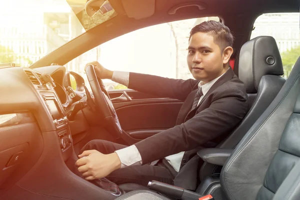 Jovem ásia homem vestindo terno condução carro — Fotografia de Stock