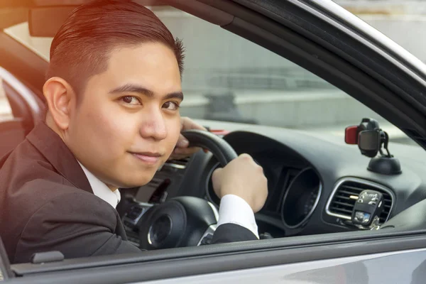 Jovem ásia homem vestindo terno condução carro — Fotografia de Stock