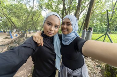 Açık havada tesettürlü iki Malezyalı Müslüman kadın.