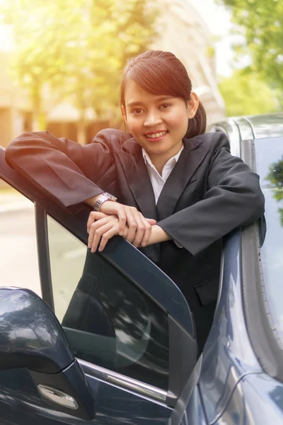 車の外でかわいいアジアの女の子は笑顔とカメラを見て Eシェアの概念 — ストック写真