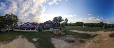 Modern ve eski, geleneksel Malay evini Kuala Kangsar, Perak 'ta terk eder.