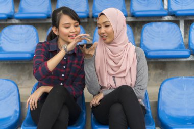 Öğrenci yaşam tarzı konsepti, şirin Asyalı kız bankta akıllı telefon kullanıyor.