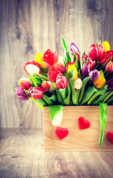 Tulips in the box on wooden background.Toned image. — Stock Photo, Image