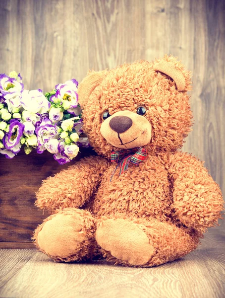 Bunch of flowers and a teddy bear — Stock Photo, Image