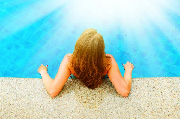 Woman relaxing in swimming pool. Back view — Stock Photo, Image