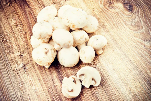 Frische Champignon-Pilze auf hölzernem Hintergrund — Stockfoto