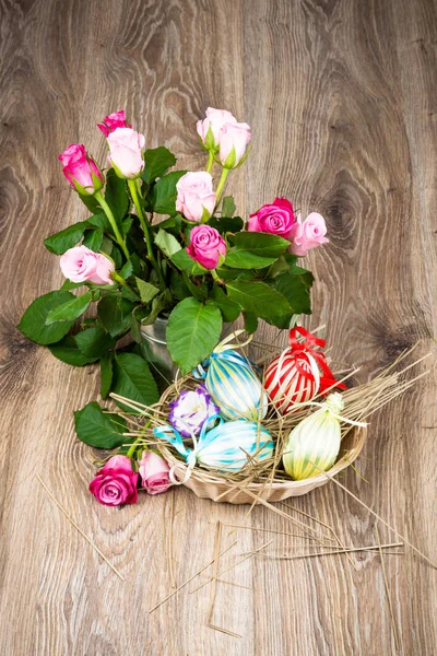 Ovos de Páscoa com flores no fundo de madeira — Fotografia de Stock