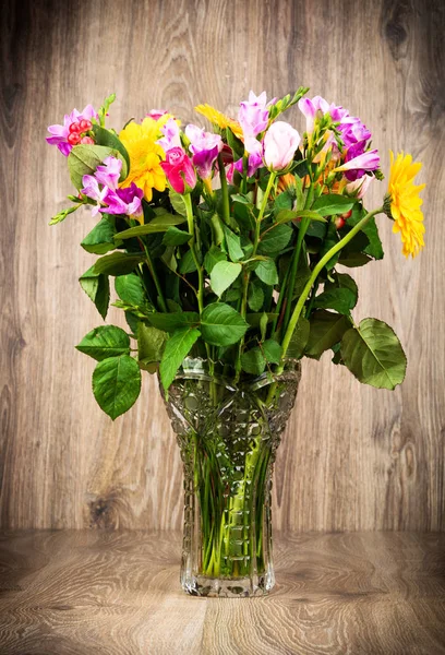 Gemischte schöne Blumen in der Vase auf Holzgrund — Stockfoto