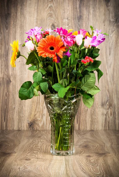 木製の背景の花瓶の美しい花を混合 — ストック写真