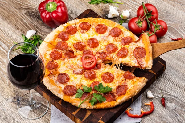 Foto de una pizza caliente sobre fondo de madera. Imagen tonificada —  Fotos de Stock