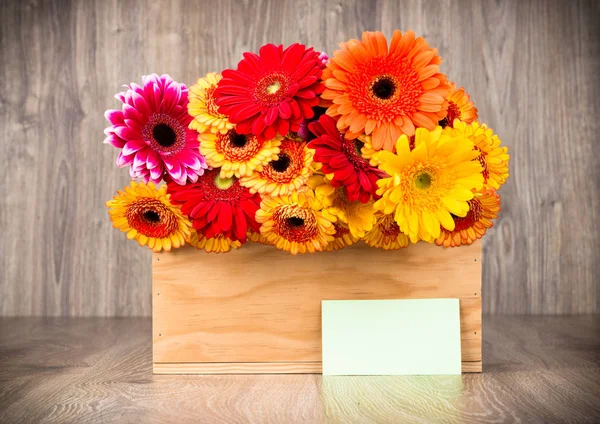 Fleurs dans la boîte sur fond en bois — Photo