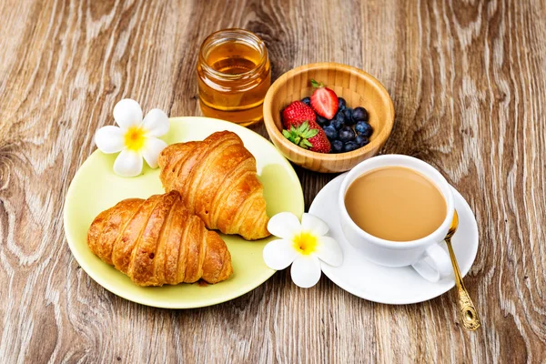 Csésze kávé és croissant-t, a fából készült háttér — Stock Fotó