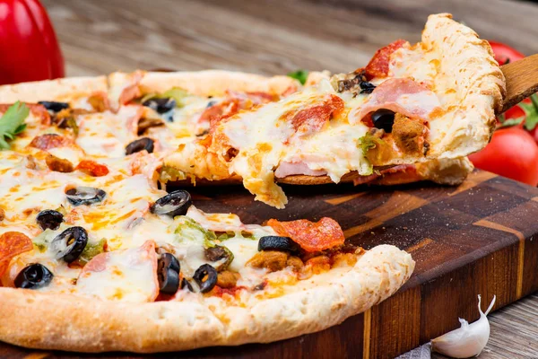 Pizza caliente sobre fondo de madera —  Fotos de Stock