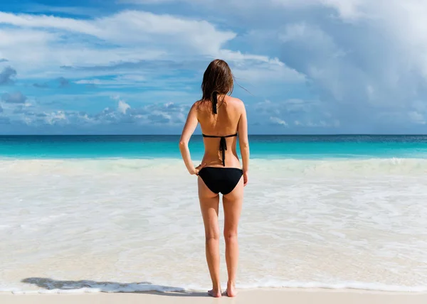 Young woman stands on the beach — Stock Photo, Image