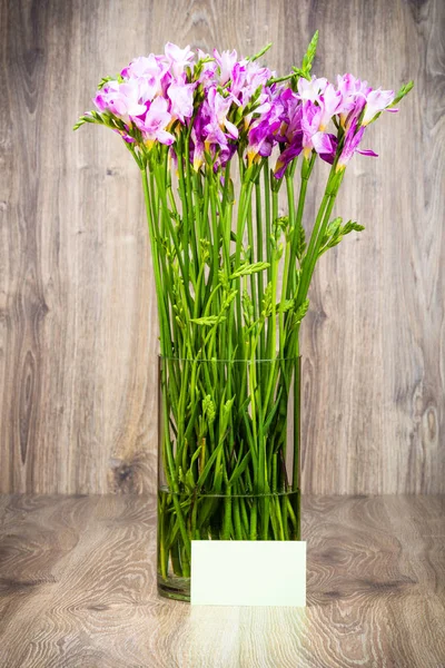 Flores freesia no vaso em fundo de madeira — Fotografia de Stock