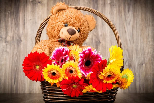 Flores y un osito de peluche sobre fondo de madera —  Fotos de Stock