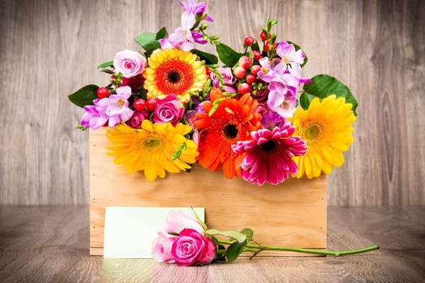 Квіти в коробці на дерев'яному тлі — стокове фото