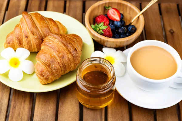 Csésze kávé és croissant-t, a fából készült háttér. — Stock Fotó