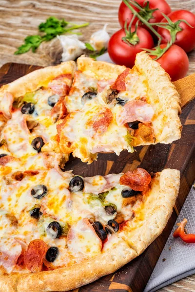 Foto de una pizza caliente sobre fondo de madera . —  Fotos de Stock