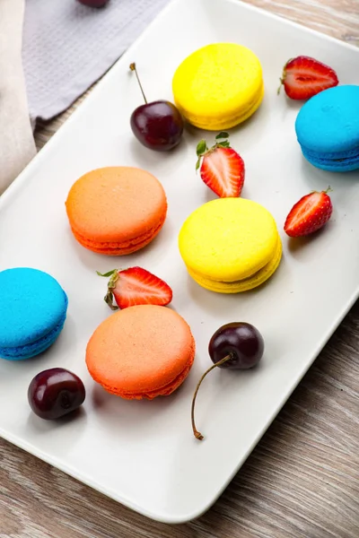 Foto de macaroons e bagas em fundo de madeira — Fotografia de Stock