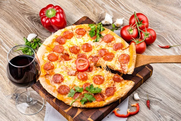 Foto de una pizza caliente sobre fondo de madera —  Fotos de Stock