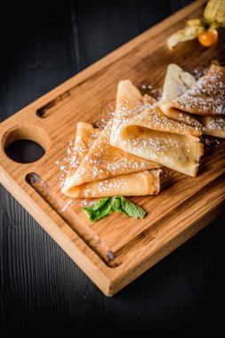 Pudra şekeri ve reçel ahşap oyun tahtası ile krep. Karanlık tablo boş alanı. Maslenitsa, Rus karnaval