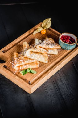 Pudra şekeri ve reçel ahşap oyun tahtası ile krep. Karanlık tablo boş alanı. Maslenitsa, Rus karnaval