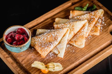 Pudra şekeri ve reçel ahşap oyun tahtası ile krep. Karanlık tablo boş alanı. Maslenitsa, Rus karnaval