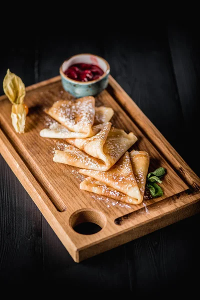 Pudra şekeri ve reçel ahşap oyun tahtası ile krep. Karanlık tablo boş alanı. Maslenitsa, Rus karnaval