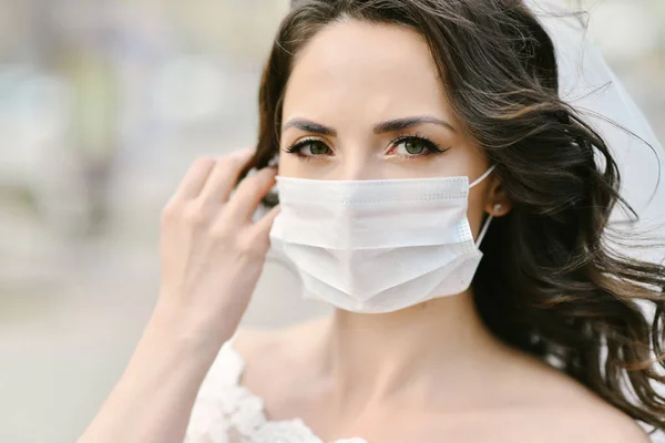 Coronavirus salgını sırasında şehrin caddesinde maske takan gelin. Düğün günü COVID-19 koruması 