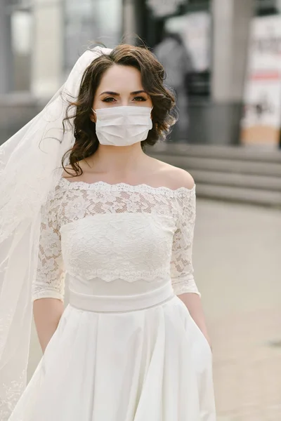 Coronavirus salgını sırasında şehrin caddesinde maske takan gelin. Düğün günü COVID-19 koruması 