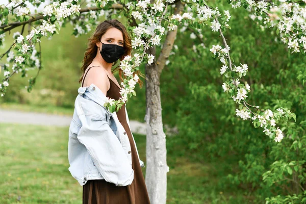 Arka Plandaki Tıbbi Maskeli Seksi Kız Elma Ağacında Çiçek Açıyor — Stok fotoğraf