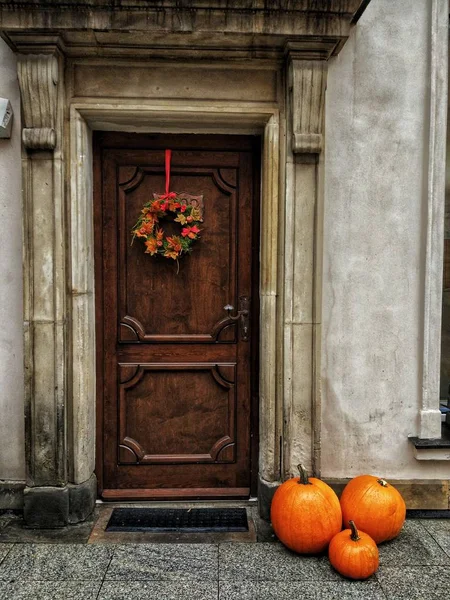 Cadılar bayramı portakalı kabakları ahşap kapının yanında.