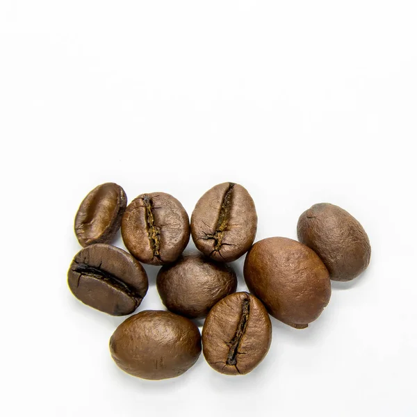 Kahve çekirdekleri beyaz arka planda ayrı yatar.