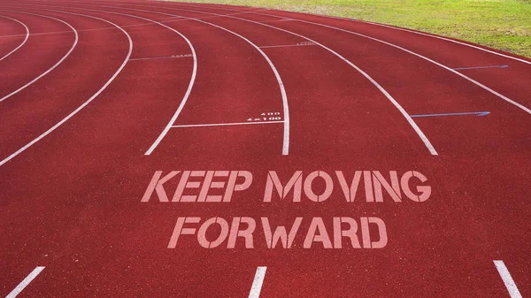 Citação motivacional escrita na faixa de corrida: Continue avançando — Fotografia de Stock