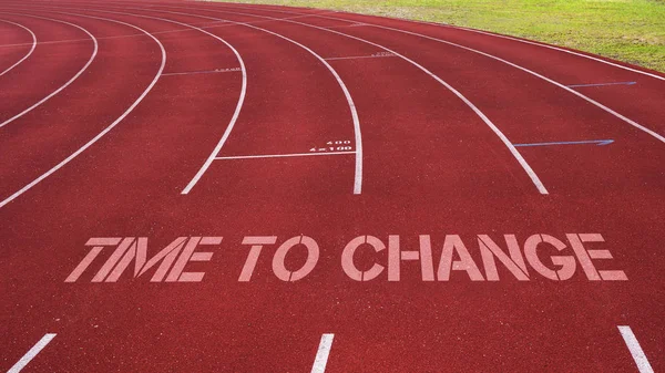 Cita motivacional escrita en pista de atletismo: Tiempo para cambiar —  Fotos de Stock