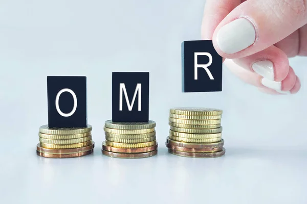 Concepto de Moneda: OMR (Rial de Omán) texto apilado en monedas con coo —  Fotos de Stock