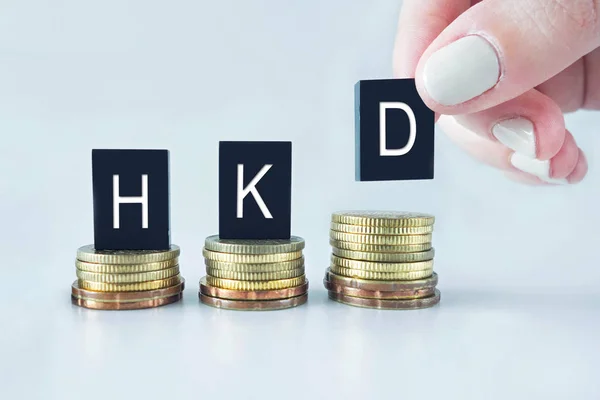 Concepto de moneda: HKD (Dolar de Hong Kong) texto apilado en monedas w Imagen De Stock
