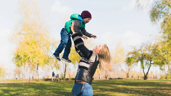 Happy mother and her son spending time in the autumn city park. — Stock Photo, Image