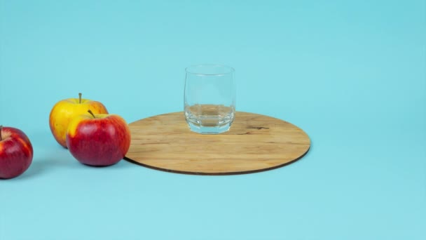 Glas Sap Met Verse Druiven Appels Blauwe Ondergrond Stop Bewegingsanimatie — Stockvideo