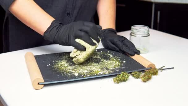 麻のケーキやパンを調理する若い女性シェフ 大麻の粉で新鮮な生地のクローズアップ 食品産業におけるマリファナの使用の概念 — ストック動画