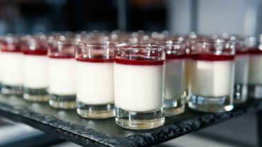 Küçük bardakta servis edilen mini cheesecake tatlılarının yakın çekimi.