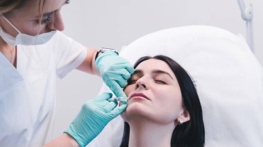 Güzellik uzmanı elleri kadın dudaklarına botoks yapıyor. Doktor.