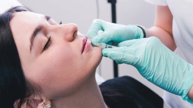 Güzellik uzmanı elleri kadın dudaklarına botoks yapıyor. Doktor.