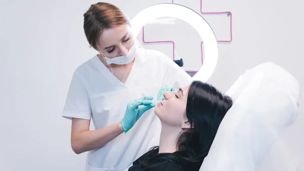 Kozmetikus kezek botox injekciót készítenek női ajkakon. A dokk — Stock Fotó