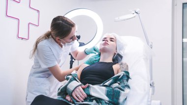 Kadın güzellik uzmanı genç kadın fraktürü enjekte ediyor.