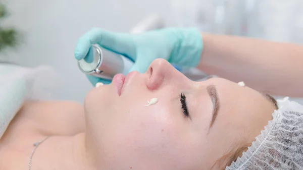 La dermatóloga hembra hace masajes faciales a la hermosa chica cosm — Foto de Stock